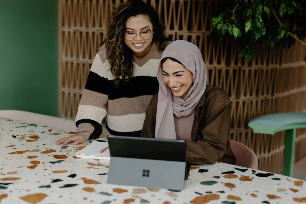 mulheres diante do computador sorrindo